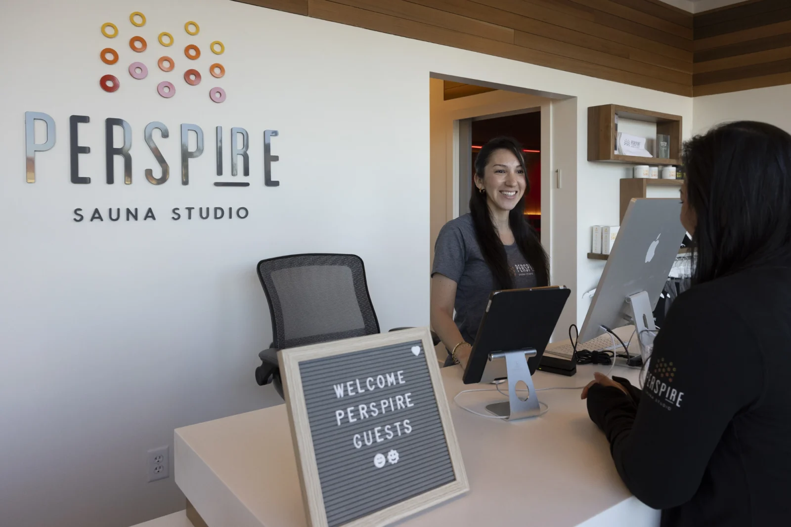 a Perspire Sauna Studio member being greeted