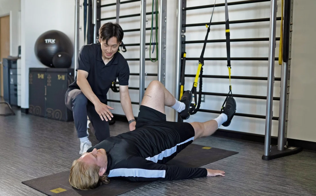 man uses TRX straps during physical therapy session