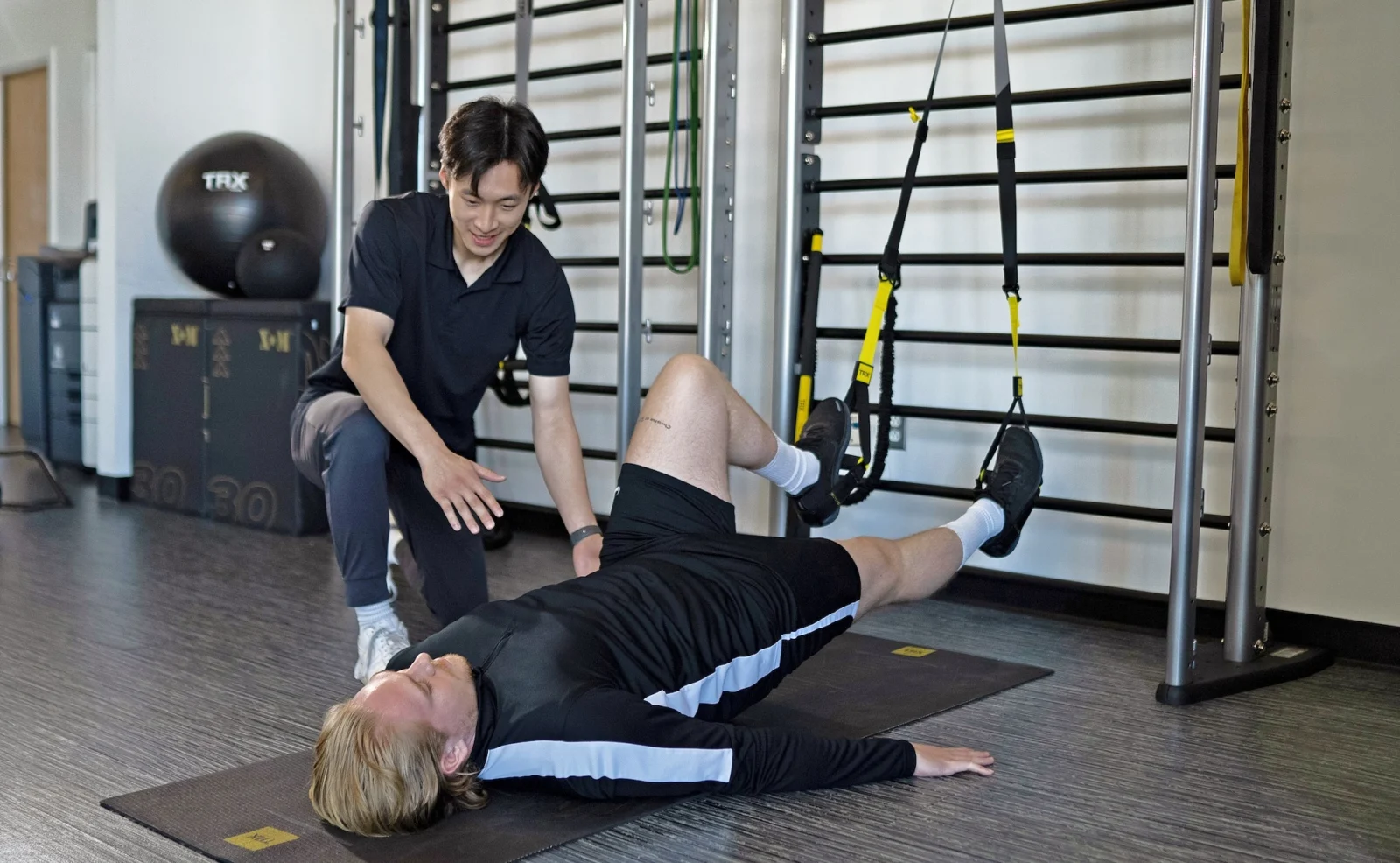 man uses TRX straps during physical therapy session