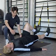 man uses TRX straps during physical therapy session