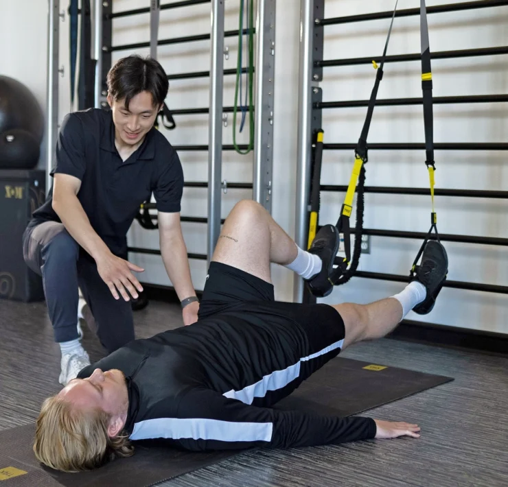 man uses TRX straps during physical therapy session