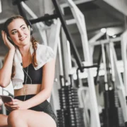 Young woman at gym with headphones on