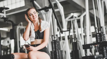 Young woman at gym with headphones on