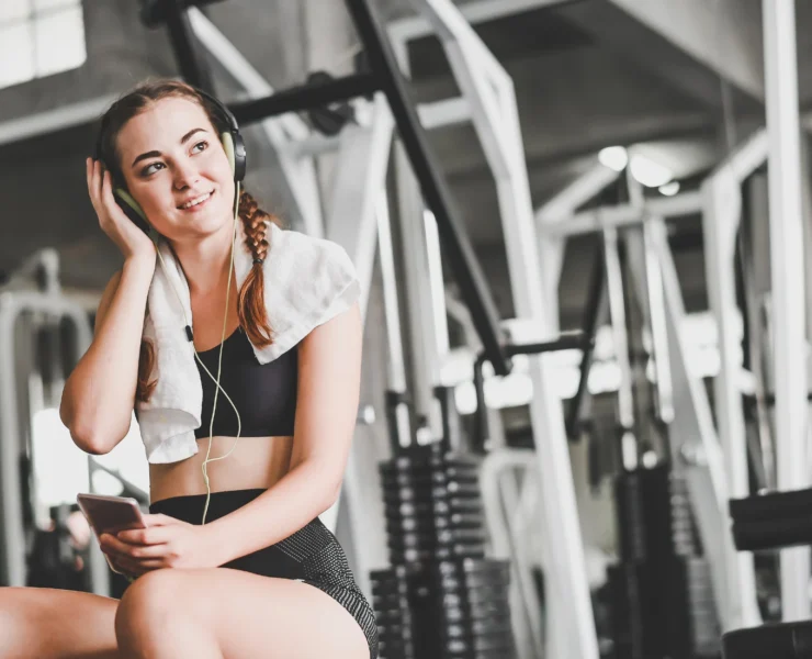 Young woman at gym with headphones on