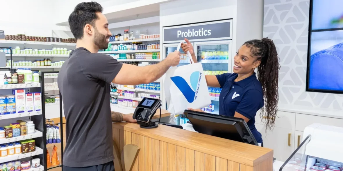 female cashier checks out a male customer at a Vitamin Shoppe location