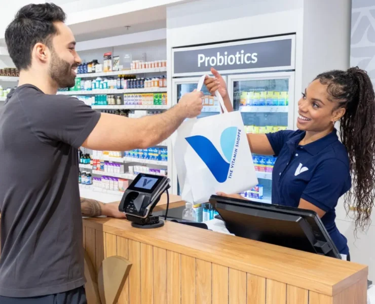 female cashier checks out a male customer at a Vitamin Shoppe location