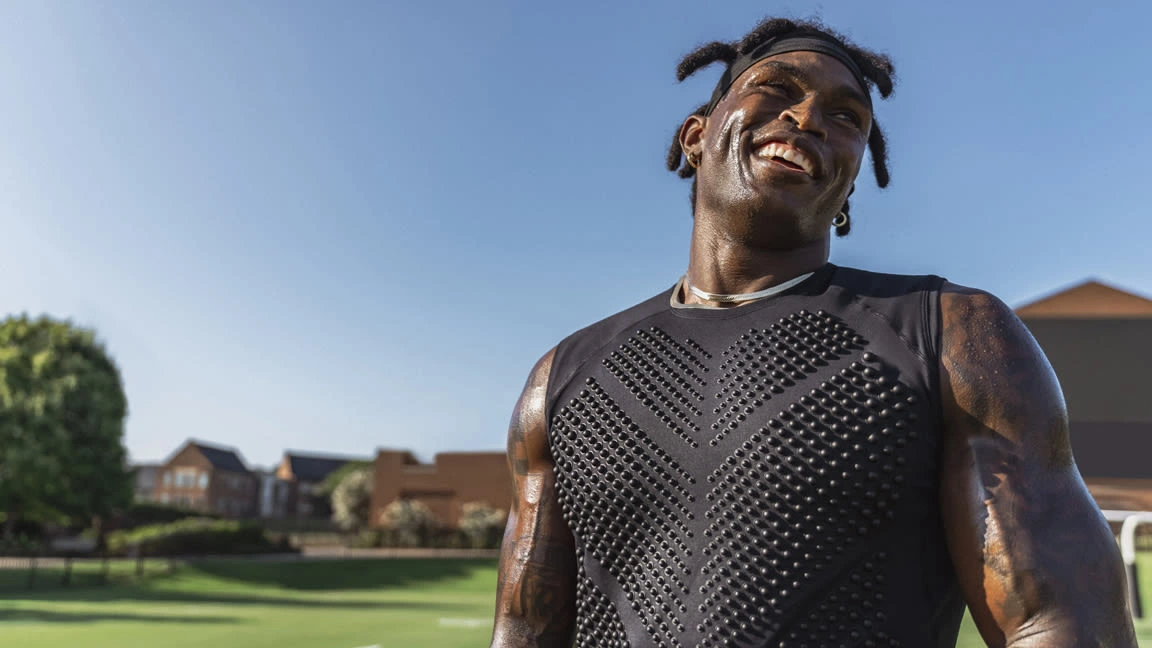 Black man wearing a weighted shirt to work out.