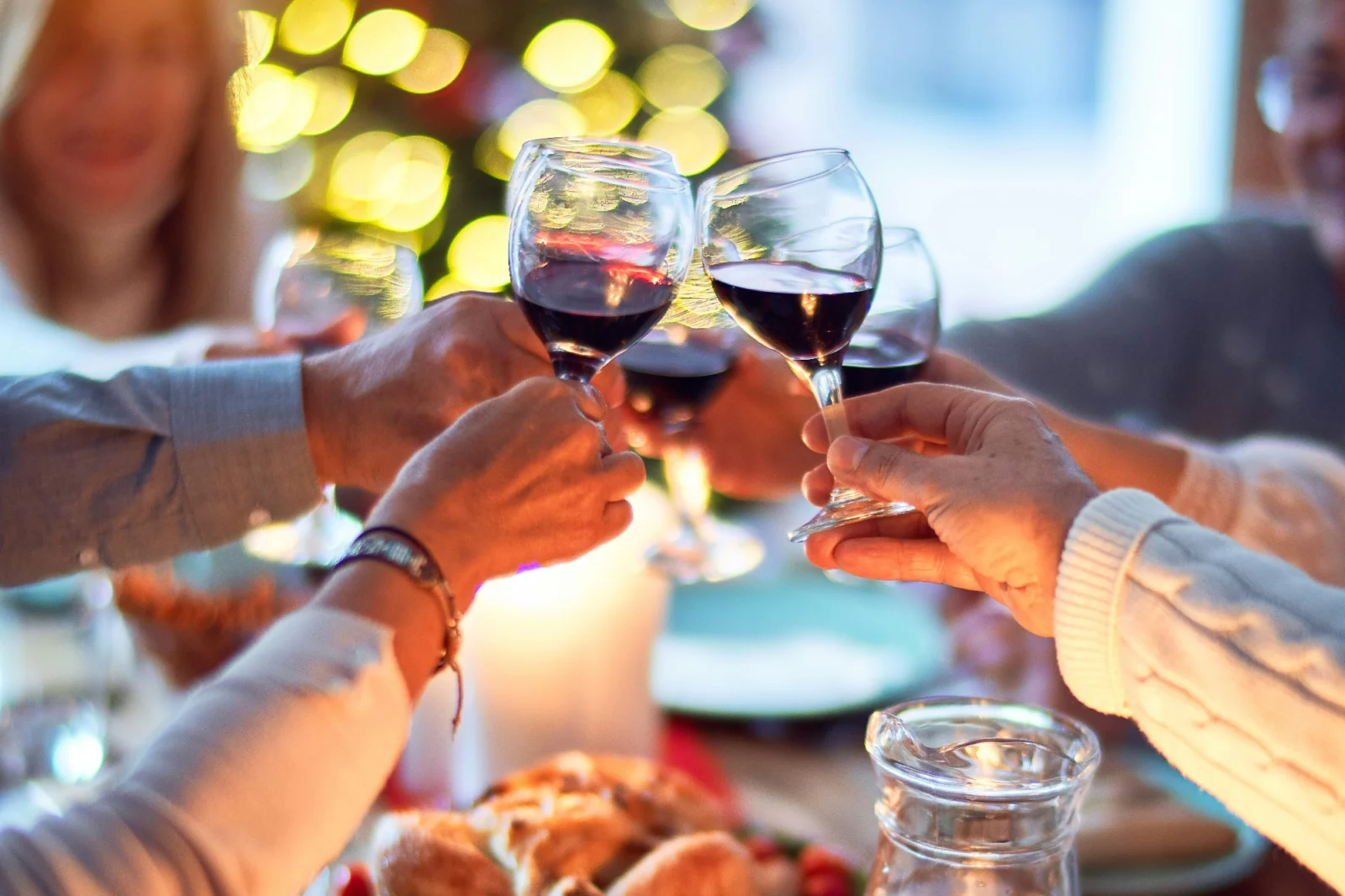 an image of four people toasting together during the holiday season