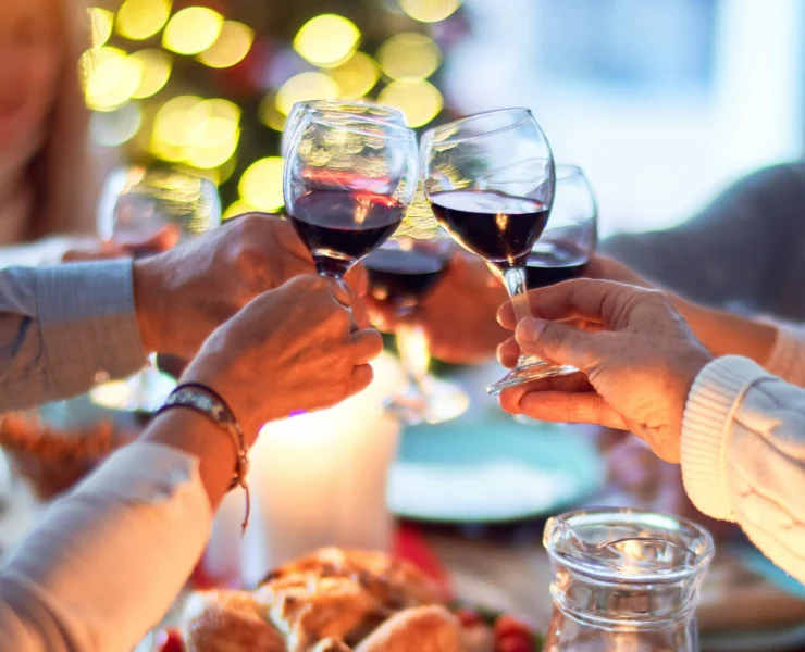 an image of four people toasting together during the holiday season