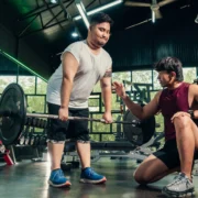 overweight man works out with help from a personal trainer