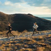 two people running along a scenic landscape