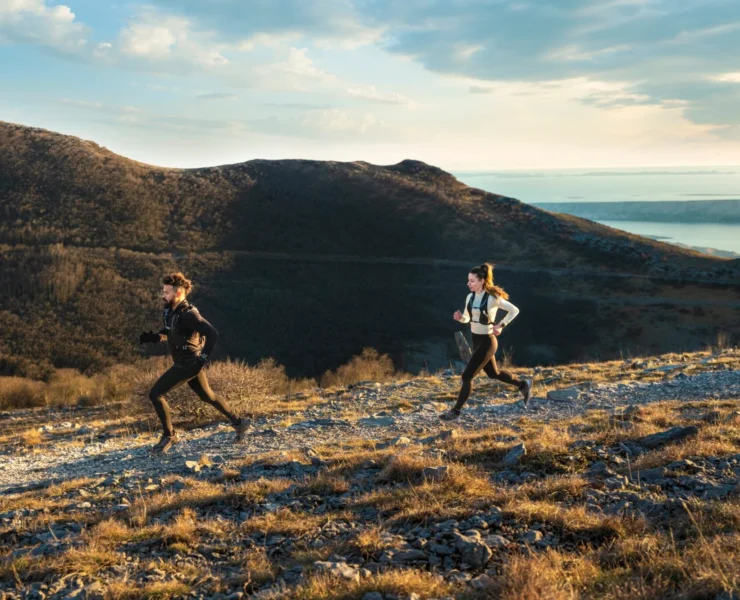 two people running along a scenic landscape