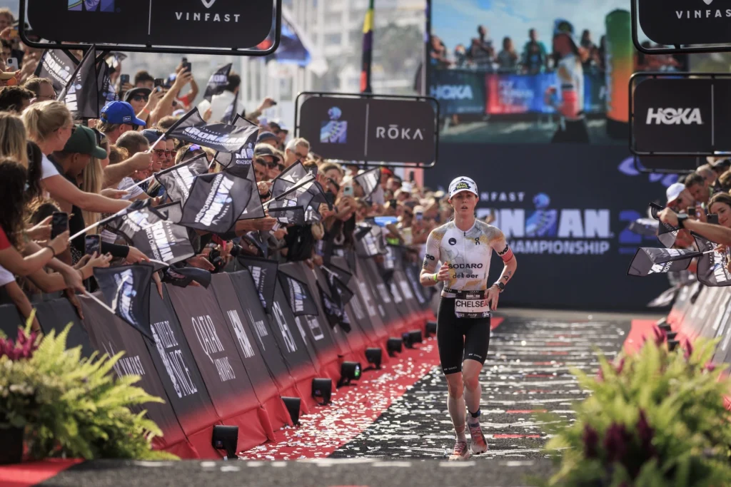 woman crosses the finishline at an Ironman triathlon