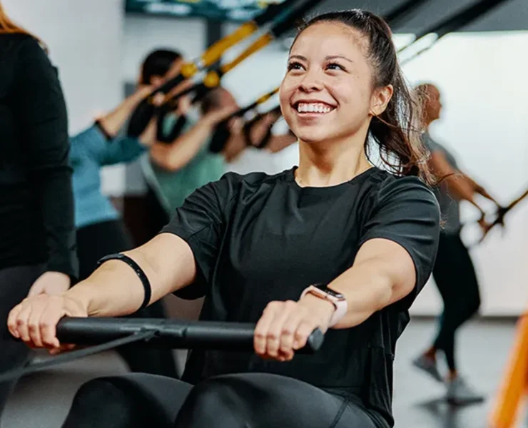 a smiling woman working out at Orangetheory Fitness