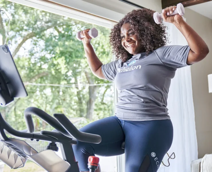 a smiling woman working out on Echelon fitness equipment