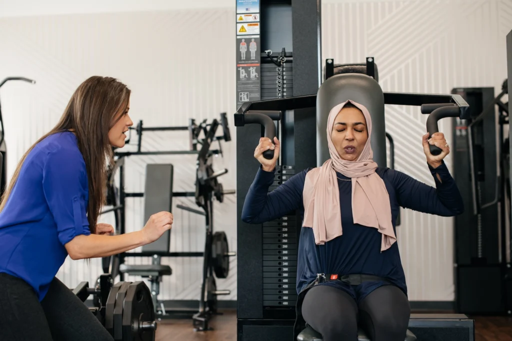 woman works out on a shoulder press machine