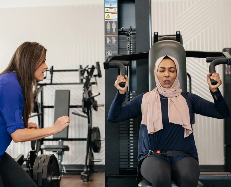 woman works out on a shoulder press machine