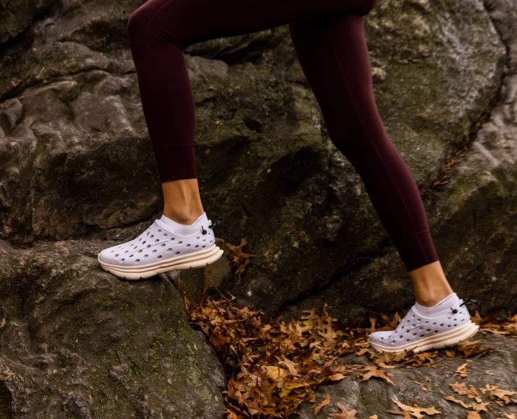 woman runs on a cliff wearing Kane shoes