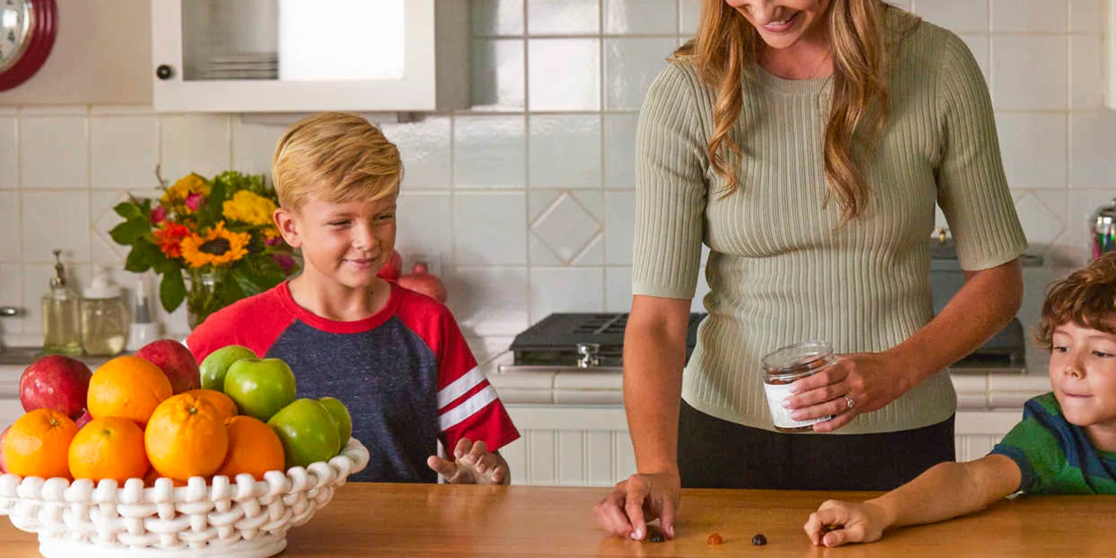 a smiling woman and young boy in the kitchen with supplements