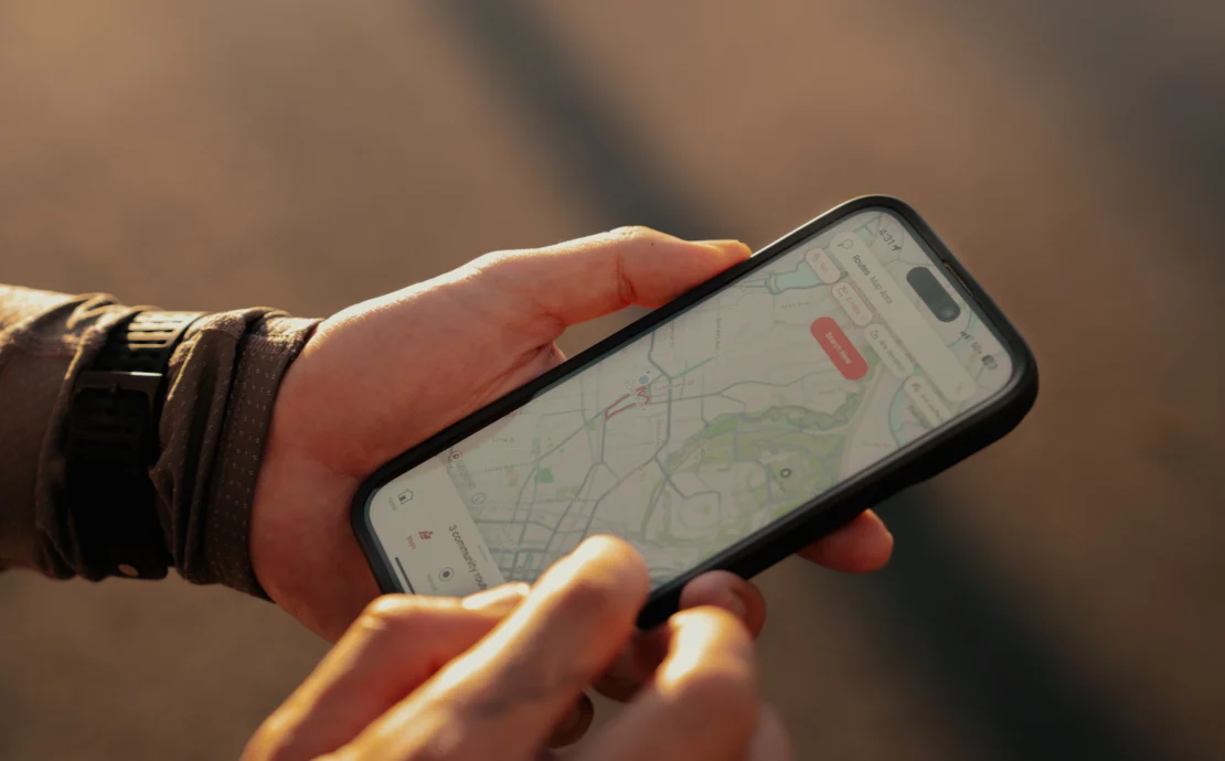 man checks the Strava app on his smartphone