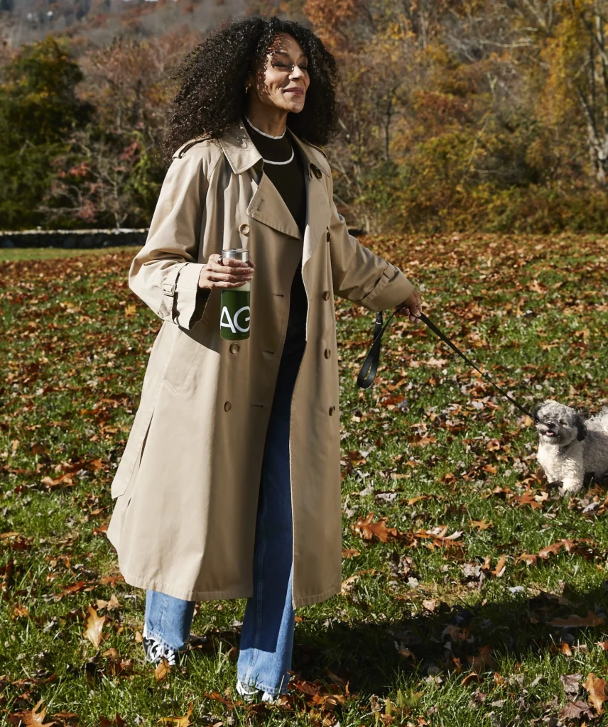 woman in a field with AG1 bottle