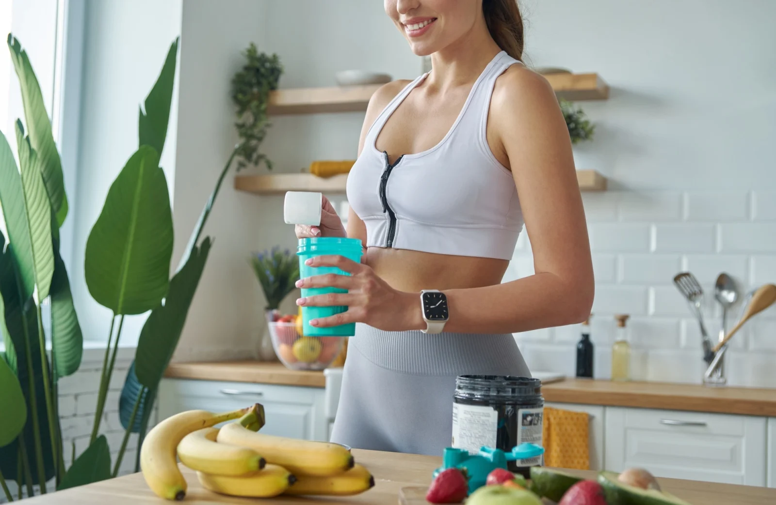 active woman pours protein powder into a shaker bottle