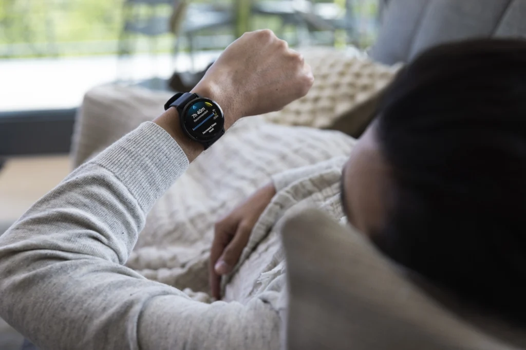 woman looks out sleep data on her Garmin smartwatch