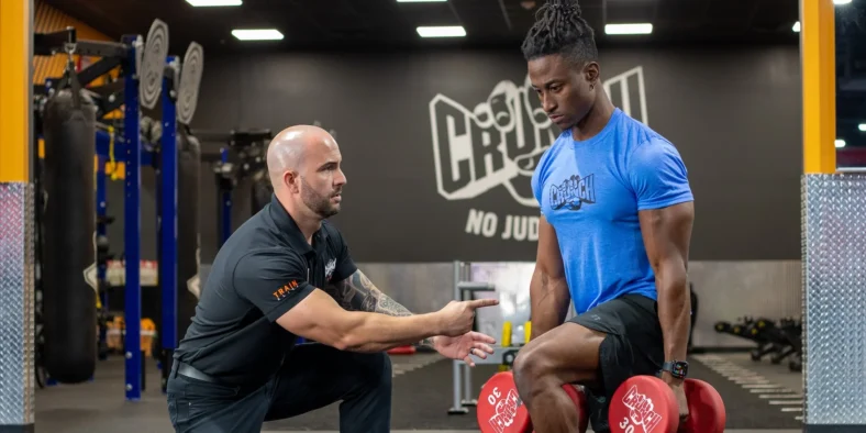 man works out at Crunch Fitness during a personal training session