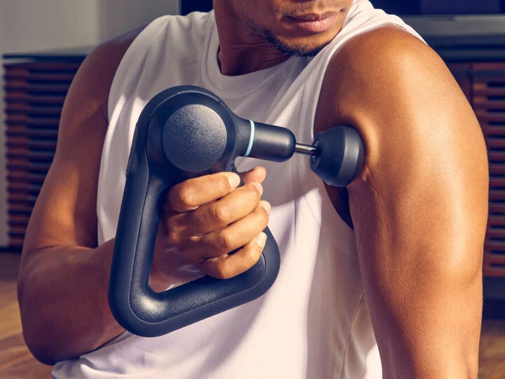 Man uses a Therabody massage gun