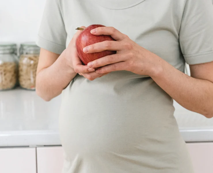 Pregnant woman holding an apple