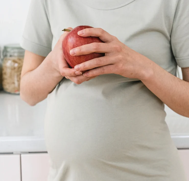 Pregnant woman holding an apple