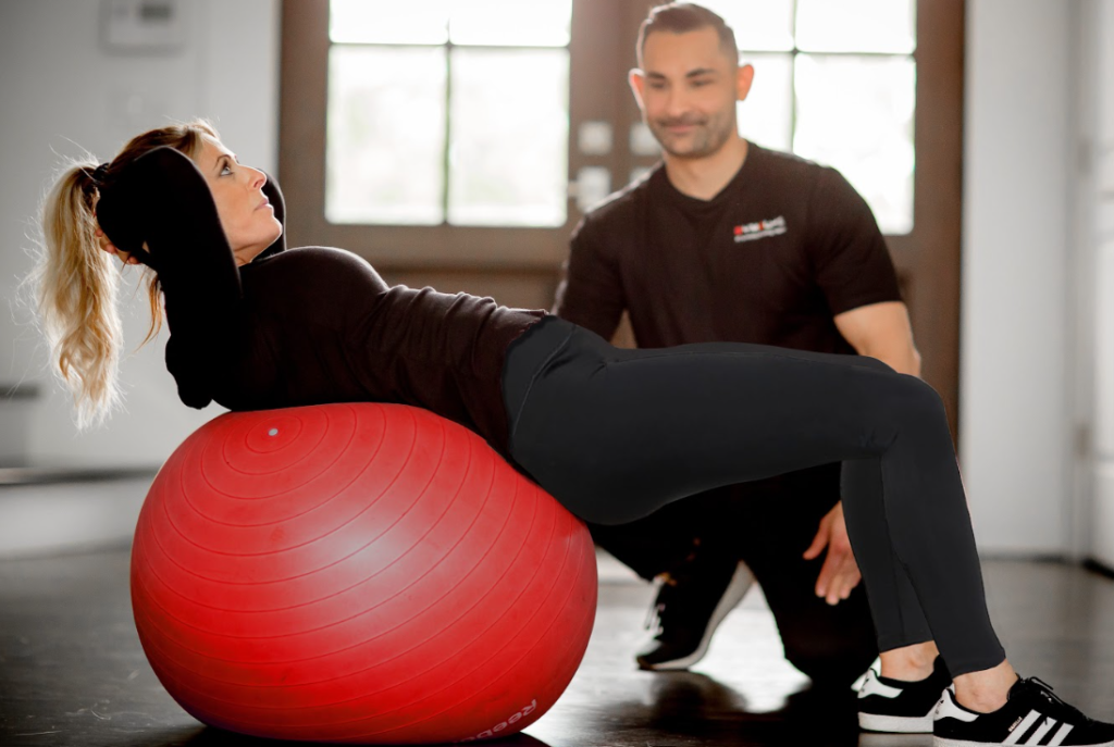 an image of a GymGuyz personal trainer assisting a client during a workout 