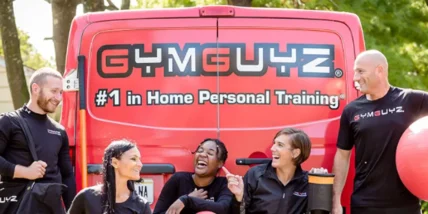 a group of GymGuyz personal trainers in front of their signature van