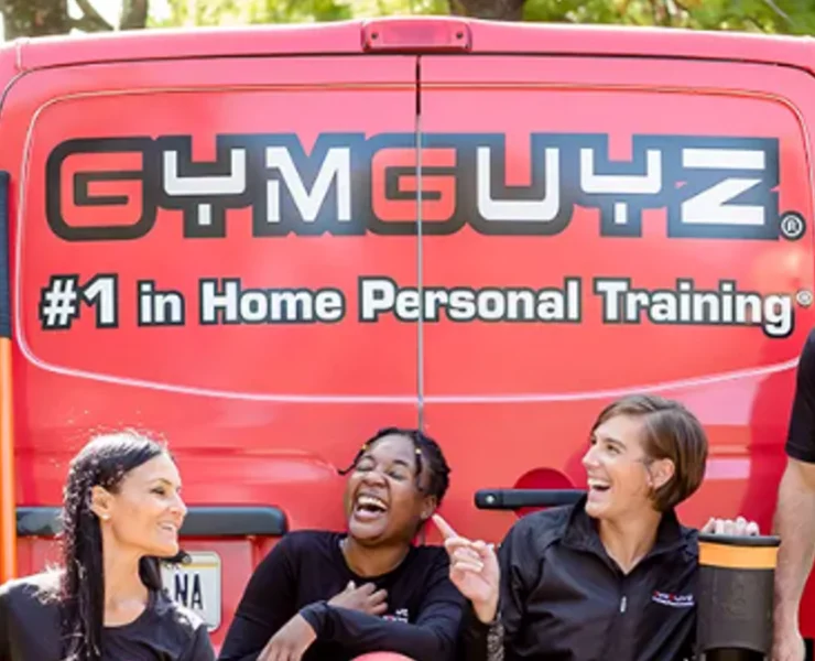 a group of GymGuyz personal trainers in front of their signature van