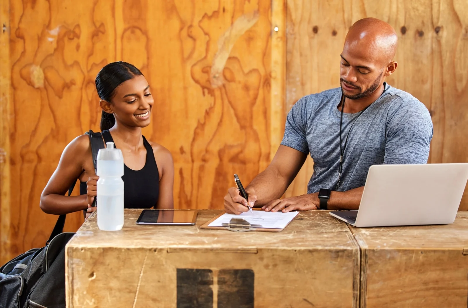 man and woman stand behind a gym desk