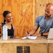 man and woman stand behind a gym desk