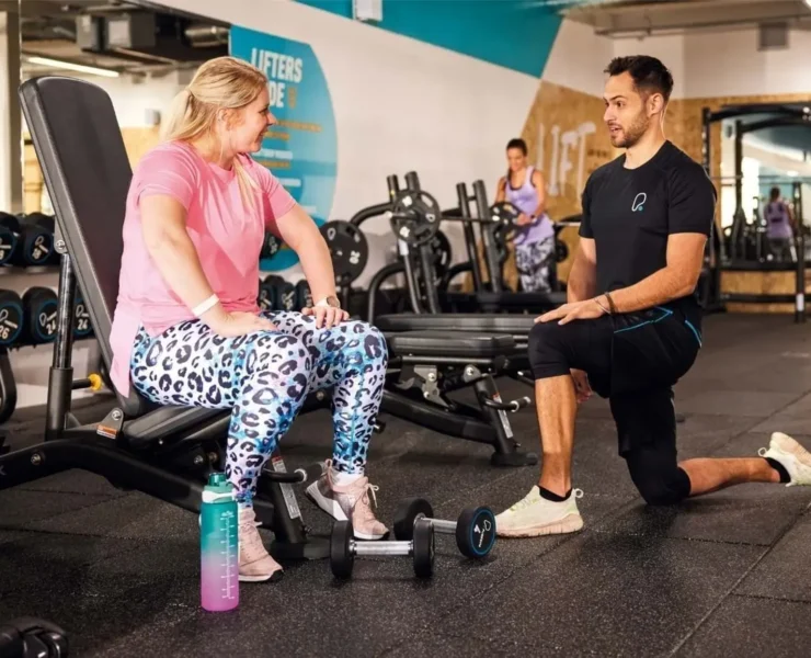 a PureGym member chats with a personal trainer