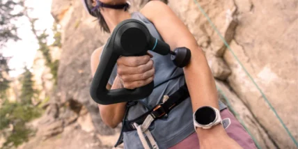 an image of a fitness enthusiast using a Garmin watch and a Theragun