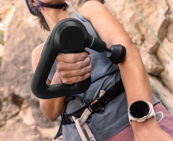 an image of a fitness enthusiast using a Garmin watch and a Theragun