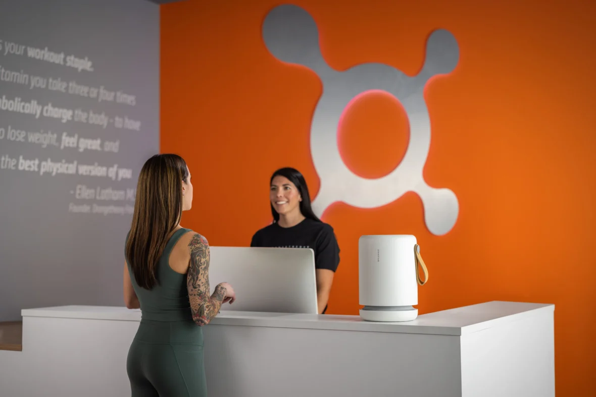 the front desk at Orangetheory with an air purifier from Molekule