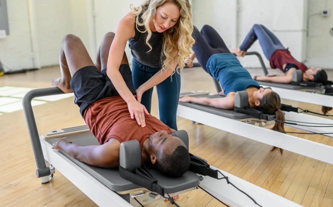 a Pilates instructors assisting a client