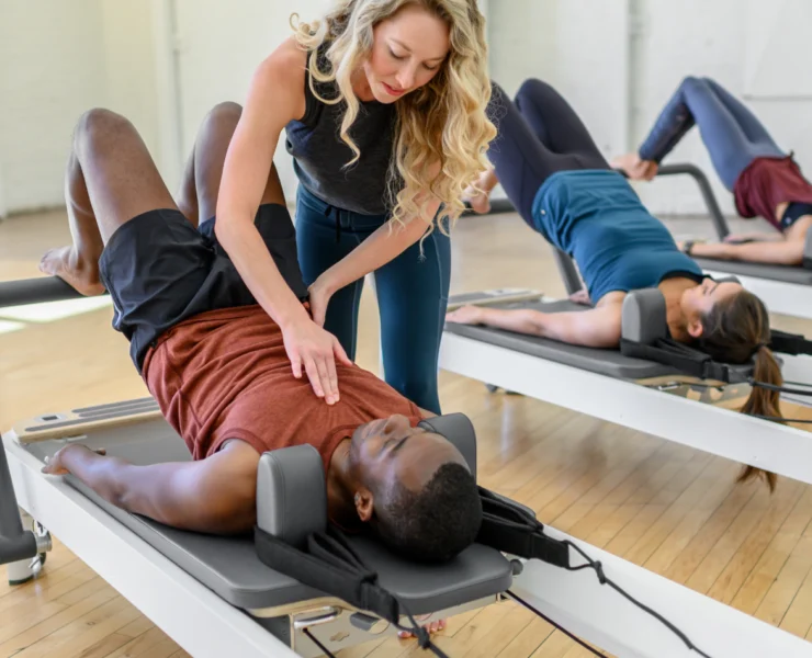 a Pilates instructors assisting a client