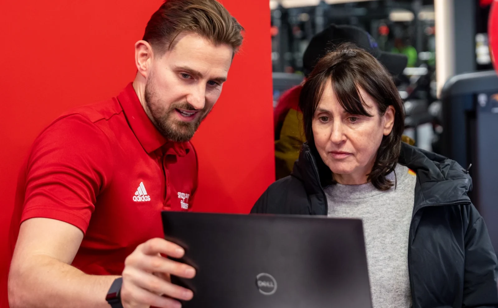 man showing woman how to use fitness app