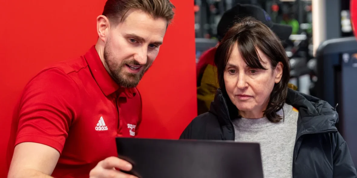 man showing woman how to use fitness app