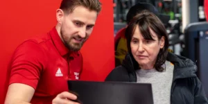 man showing woman how to use fitness app
