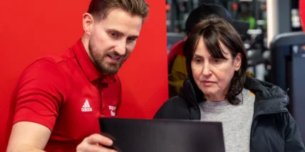 man showing woman how to use fitness app