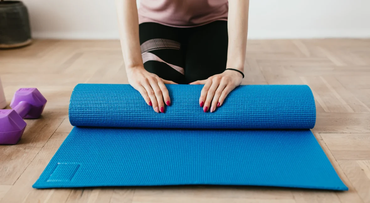 Woman with yoga mat, unrolling