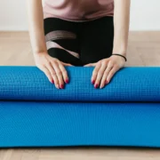 Woman with yoga mat, unrolling
