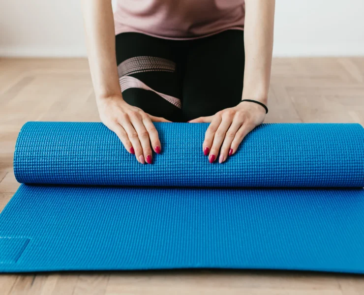 Woman with yoga mat, unrolling