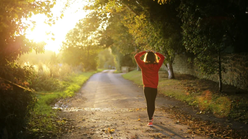 an image of a woman walking outside at dusk/mental wellness